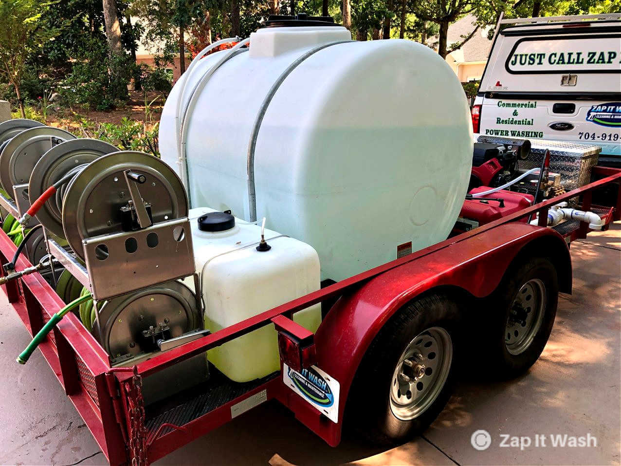 A power washing trailer being used to power wash a home.